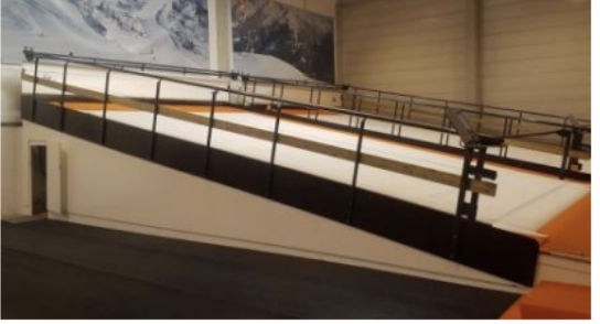 Ski treadmill simulator lane with mountain mural backdrop